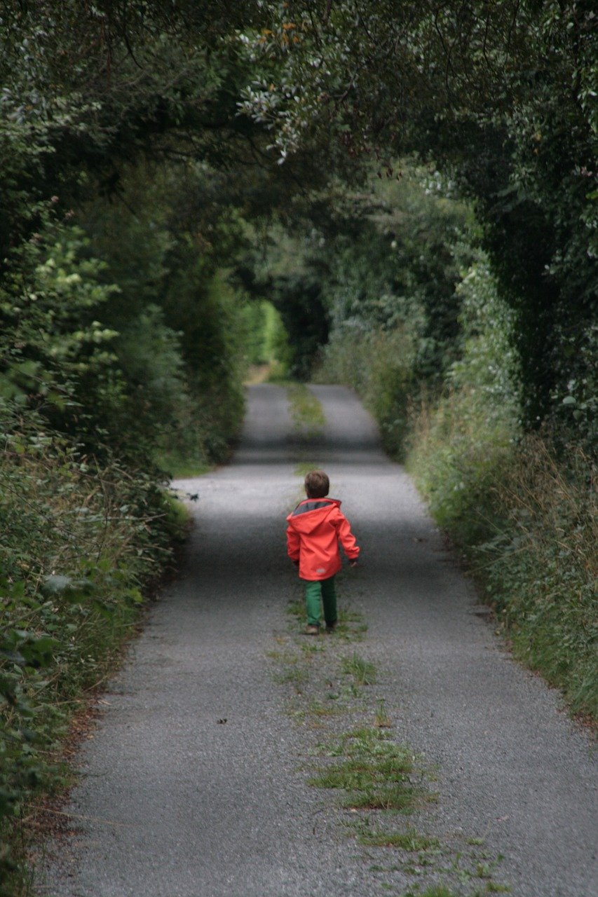 Un bambino cammina da solo lungo un sentiero isolato