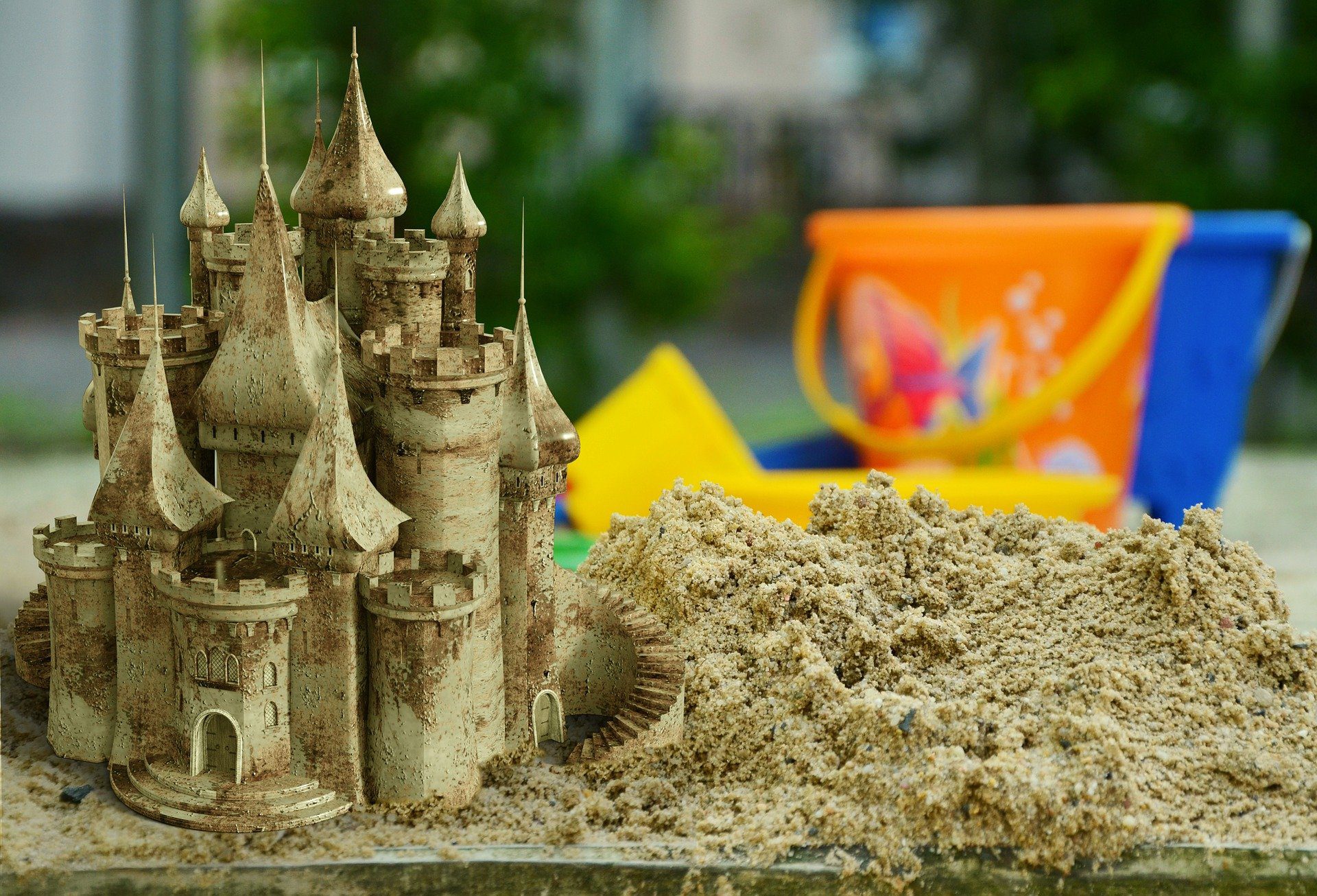 un castello elaborato di sabbia con secchiello e paletta sullo sfondo