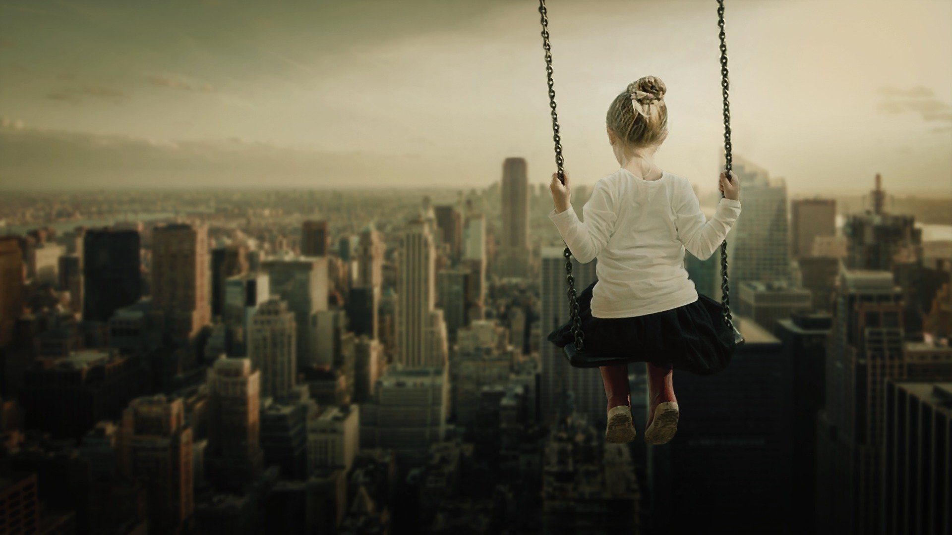 una bambina di spalle su un'altalena sopra newyork