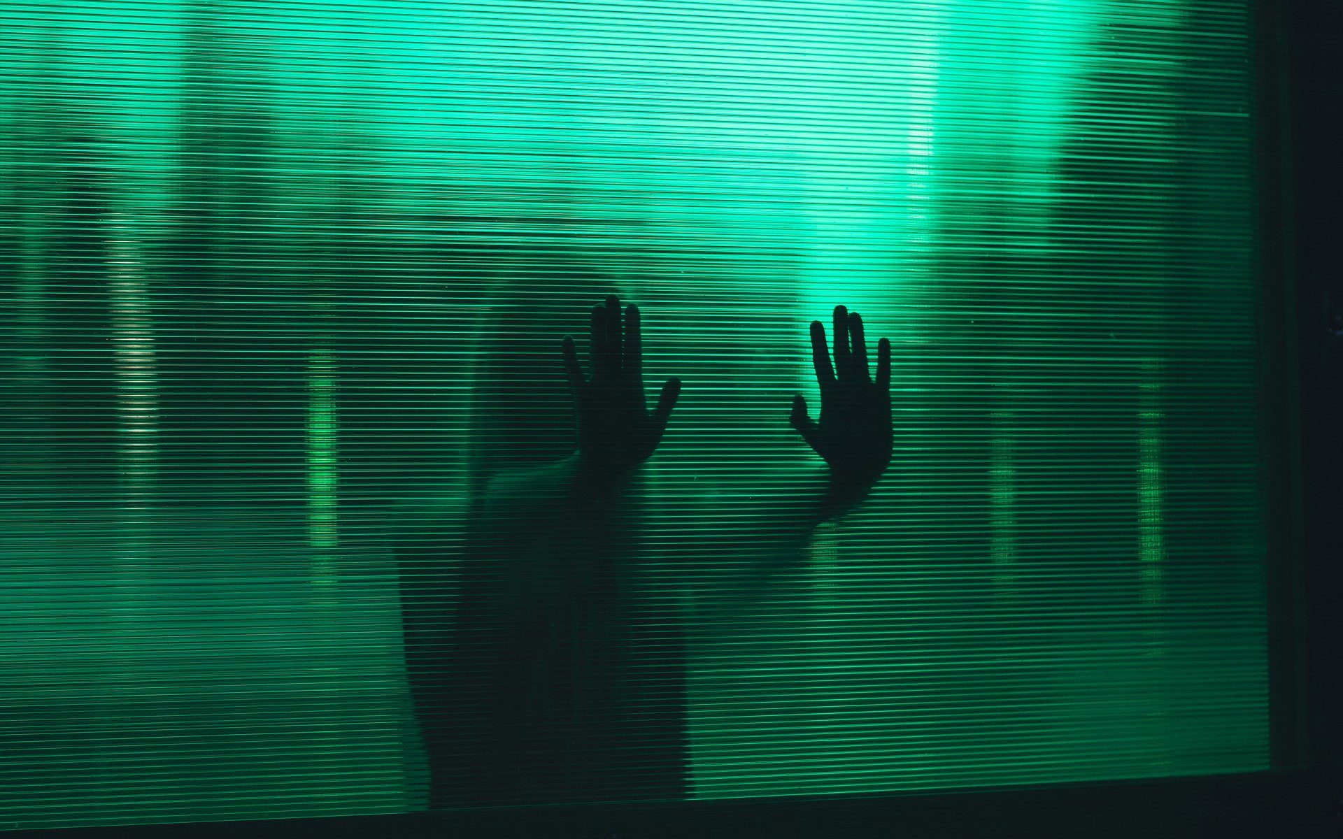 donna che appoggia le mani su un muro verde trasparente