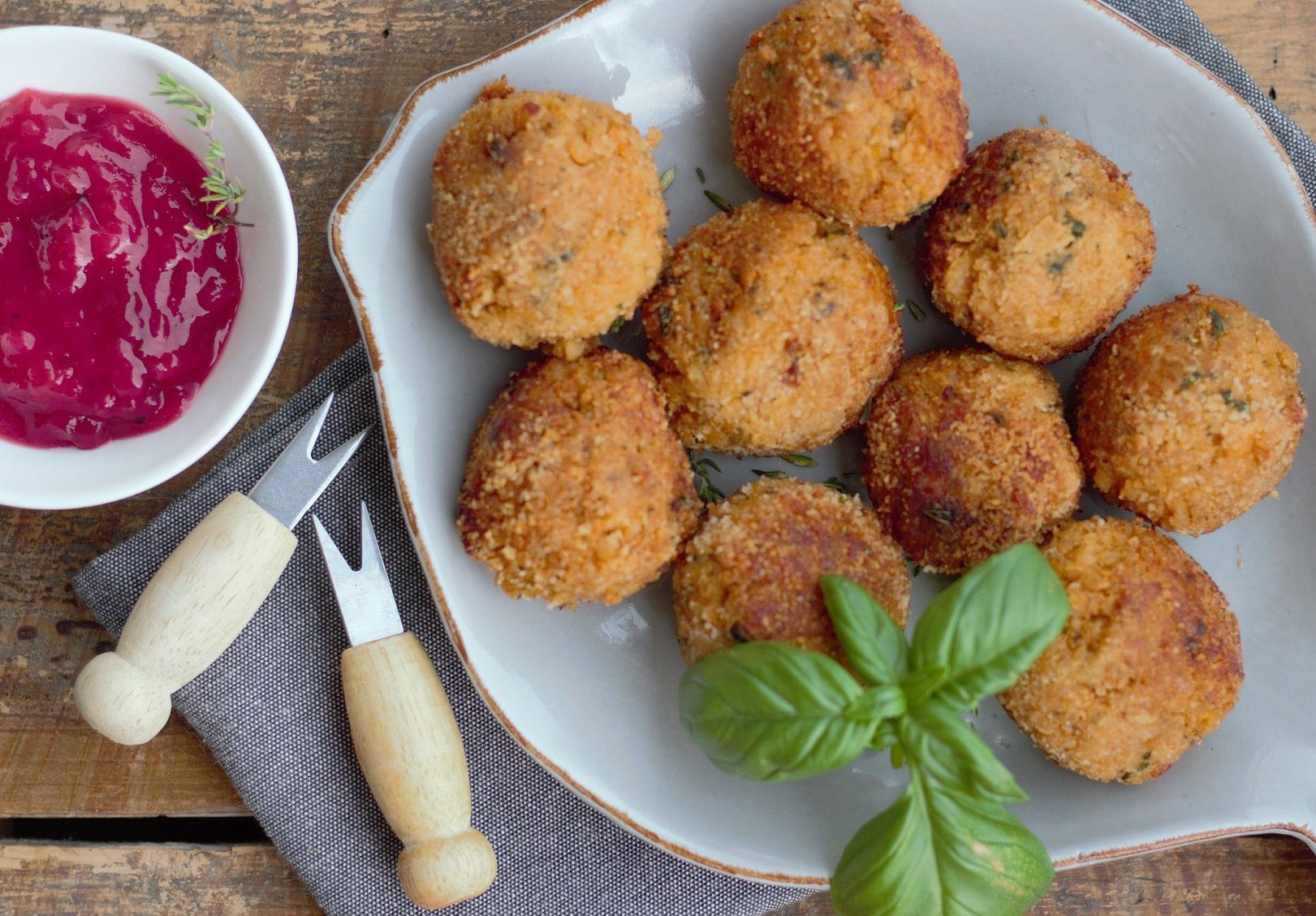 piatto con polpette, una salsa rossa, forchettine da buffet e basilico