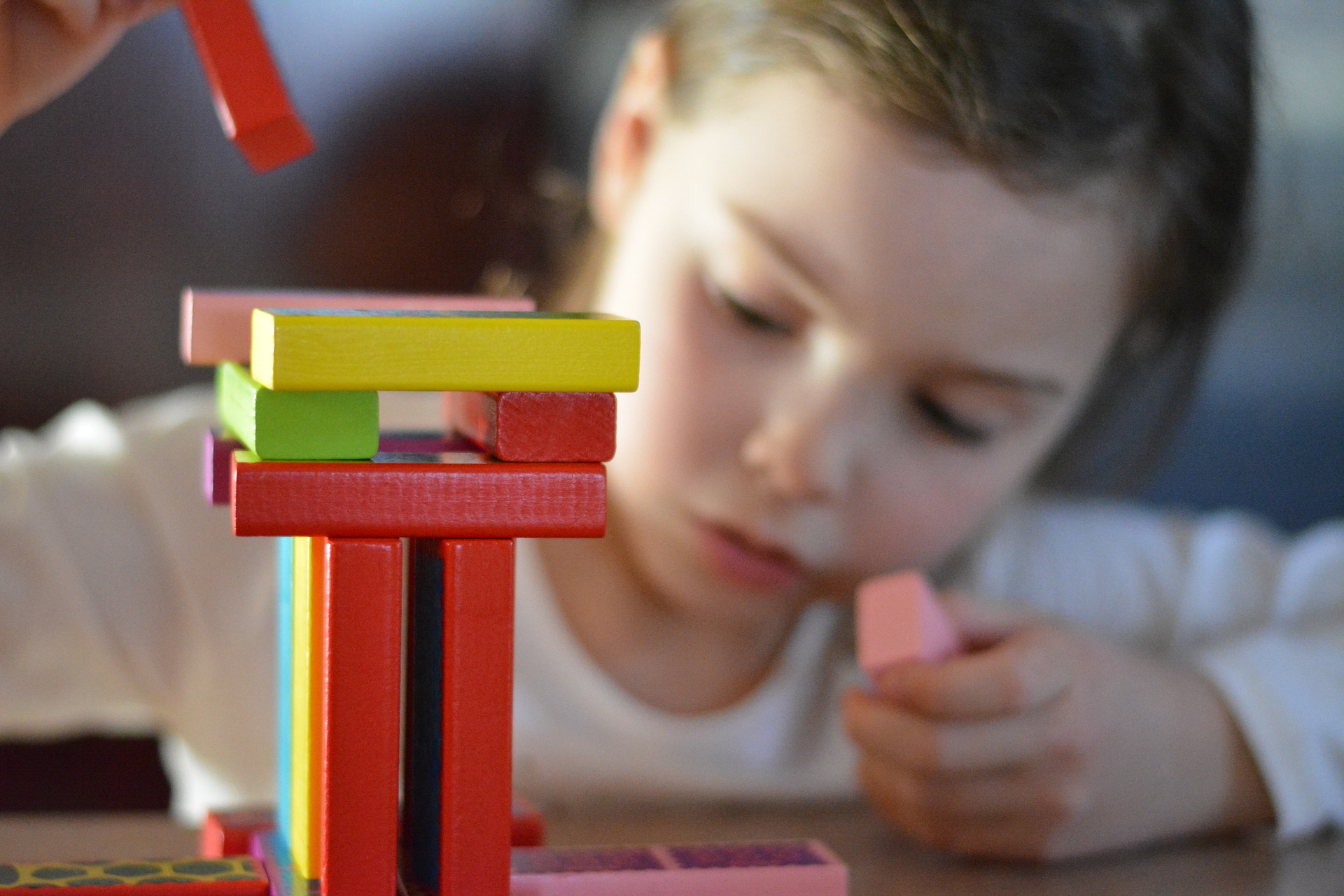 una bambina gioca con i mattoni colorati